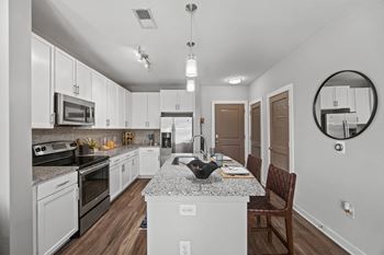 A modern kitchen with white cabinets and a granite countertop.